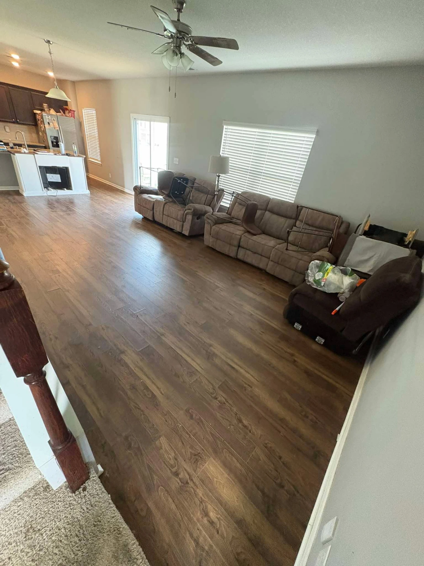 After cleaning: the same living room with clear, freshly cleaned hardwood floors and tidy furniture